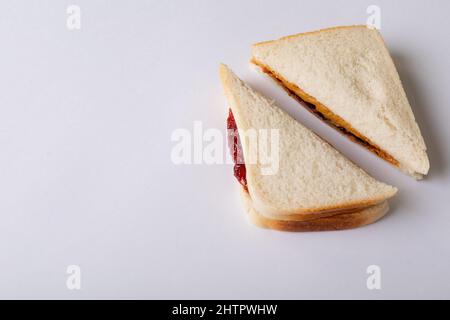 Nahaufnahme von halbierten Erdnussbutter- und Gelee-Sandwiches auf weißem Hintergrund mit Platz zum Kopieren Stockfoto