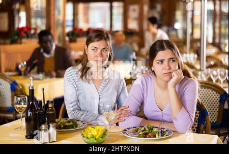 Frau beruhigt ihre Freundin im Restaurant Stockfoto