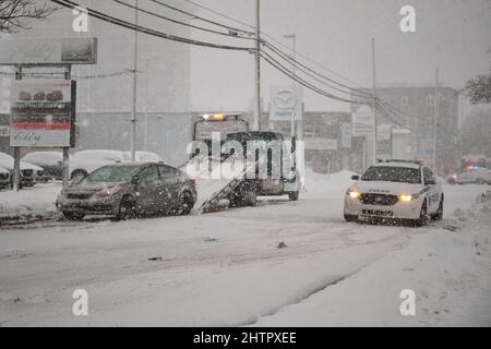 Halifax, Kanada. 2.. März 2022. Ein Schneewintersturm, der voraussichtlich bis zu 10cm Schnee auf der Stadt bringen wird, trifft die Straße von Halifax und sorgt so für einen schwierigen morgendlichen Pendelweg. Einer der vielen Autounfälle auf der Straße, die mit einem Polizeiauto am Tatort in der Robie Street entfernt wurden. Stockfoto