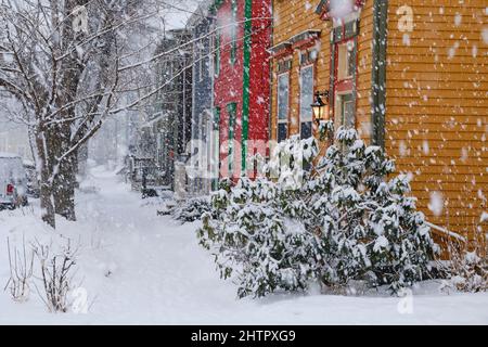 Halifax, Kanada. 2.. März 2022. Ein Schneewintersturm, der voraussichtlich bis zu 10cm Schnee auf der Stadt bringen wird, trifft die Straße von Halifax und sorgt so für einen schwierigen morgendlichen Pendelweg. Stetiger Schnee fällt auf die bunten traditionellen Häuser der Halifax North Area. Stockfoto