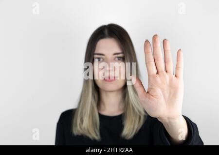 Junges blondes Mädchen in legerer Kleidung, das über einem isolierten weißen Hintergrund steht und mit den Fingern Nummer fünf nach oben zeigt. Stockfoto