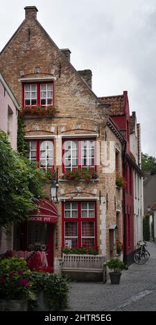 Vertikale Aufnahme eines alten europäischen Mehrfamilienhauses mit einem Dreiecksdach und roten Fenstern Stockfoto