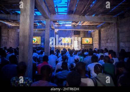 Freetown, Sierra Leone. 12. Januar 2022. Die Einheimischen schauen sich ein Fußballspiel in einem ''Kino'' in Freetown an.Sierra Leone qualifizierte sich 2022 zum ersten Mal seit 26 Jahren für den Africa Cup of Nations und gab vielen lokalen Fußballspielern Hoffnung, dass sie künftig mehr internationale Chancen erhalten werden. (Bild: © Sally Hayden/SOPA Images via ZUMA Press Wire) Stockfoto