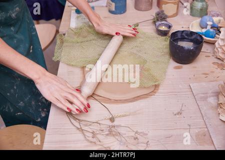 Herstellung einer durchbrochenen Tafel aus Ton mit einer gestrickten Serviette. Stockfoto