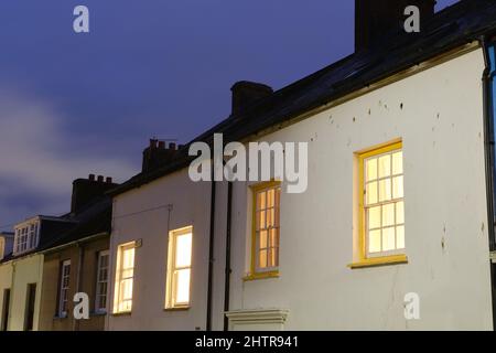 Nachtansicht der traditionellen Reihenhäuser mit angeleuchtenden Schlafzimmern Stockfoto