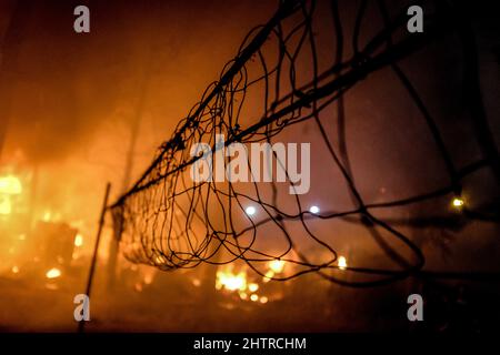 Nairobi, Kenia. 1. März 2022. Ein lokaler Wald brennt während eines Brandausbruchs in den Slums von Kibera durch einen Volleyball-Torpfosten nieder. Am 1.. März 2022. Die Bewohner der Slums von Kibera erlebten einen weiteren Verlust, als sie von einem Feuer, das spät in der Nacht auftrat und zwanzig Häuser niederwüste, nicht bemerkt wurden, und die meisten Einheimischen obdachlos blieben und sich an nichts wenden konnten. Der Ausbruch des Feuers war auf verworrene Drähte aus illegalen elektrischen Verbindungen zurückzuführen. (Bild: © Donwilson Odhiambo/ZUMA Press Wire) Stockfoto