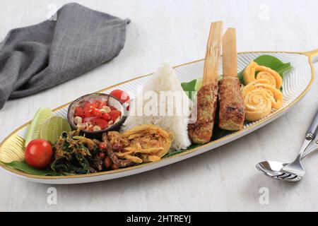 Nasi Campur Bali. Balinesisches Gericht aus gedämpftem Reis mit verschiedenen Beilagen wie Sate Lilit, Ayam Pelalah, Telur Dadar, Kacang Teri, Jukut Urap. Stockfoto