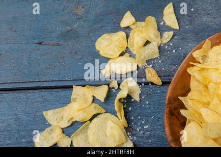 Direkt über Schuss der Kartoffelchips mit Salz auf dem Holztisch Stockfoto