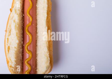 Nahaufnahme eines Hot Dogs mit muffrierter Sauce auf weißem Hintergrund mit Platz zum Kopieren Stockfoto