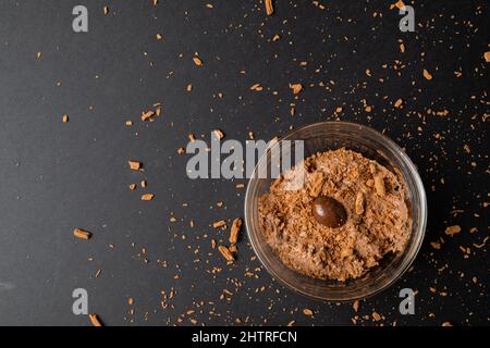 Ansicht von oben von Schokoladenmousse mit beschichteter Nuss und geschredderter Schokolade, serviert in einer Schüssel auf dem Tisch Stockfoto