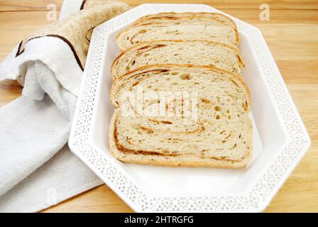 Roggen und Pumpernickel wirbelten Brotlaib auf einer weißen Platte Stockfoto