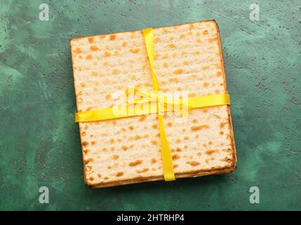 Jüdische Fladenbrot-Matza für Passah mit Band auf grünem Hintergrund Stockfoto