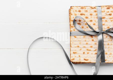 Jüdische Fladenbrot-Matza für Passah mit Band auf weißem Holzhintergrund Stockfoto