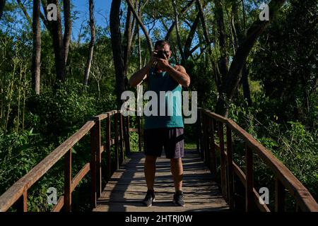 Junger Mann fotografiert in der Natur mit einer Vintage-Kamera Stockfoto