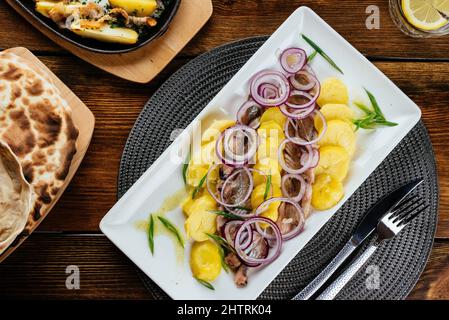 Gekochte Kartoffeln und eingelegter Hering. Speisekarte des Restaurants Stockfoto