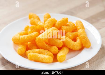 Ein Haufen Wotsits auf einem weißen Teller Stockfoto