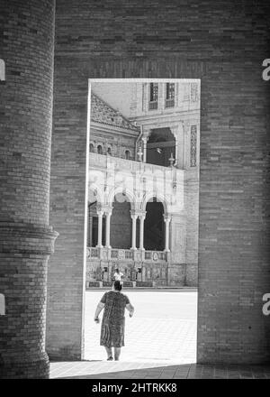 Vertikale Aufnahme einer Person unter der schönen Architektur in der Nähe von Maria Luisa Park, Sevilla, Spanien Stockfoto