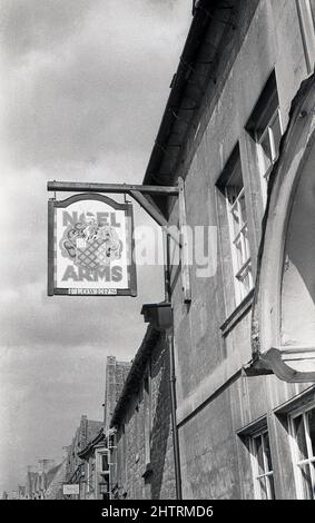 1950s, historisch, Schild für das Noel Arms Hotel in Chippng Campden, Gloucestershire, England, Großbritannien, eine Marktstadt, die für ihre Architektur und insbesondere ihre alte, terrassierte High Street aus dem 14.. Jahrhundert bekannt ist. Das Noel Arms war in dieser Zeit Teil der Blumenbrauerei. Gegründet 1831 in Stratford-upon-Avon als Flowers & Sons, wurde es Mitte 1950s nach der Fusion mit J. W Green zu Flowers Breweries, bevor es 1961 von Whitbread übernommen wurde. Stockfoto