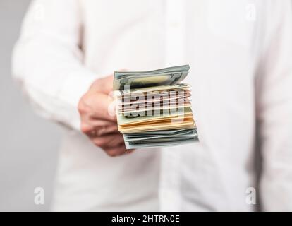 Geschäftsmann Hand geben US-Dollar Stapel. Zahlung, Gehalt in bar Konzept. Hochwertige Fotos Stockfoto