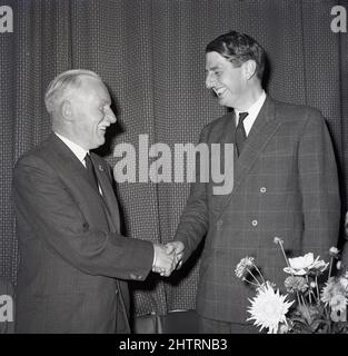 1960s, historisch, der 10. Duke of Atholl (Iain Murray) in einem Karokuit mit einer zweireihigen Jacke, die einem Mann bei einer Präsentation die Hand schüttelt, Schottland, Großbritannien. Ein großer Mann, sechs Fuß, fünf Zoll, liebevoll bekannt als "Wee Iain", wurde er 10. Herzog im Jahr 1957. Der Titel im Peerage of Scotland, der vom Leiter des Clan Murrary gehalten wurde, stammt aus dem Jahr 1703, als er von Königin Anne für John Murray, 2. Marquess of Atholl, geschaffen wurde. Die Familie oder das Stammhaus von Clan Murray ist Blair Castle, in der Nähe des Dorfes Blair Atholl, Perthshire. Stockfoto