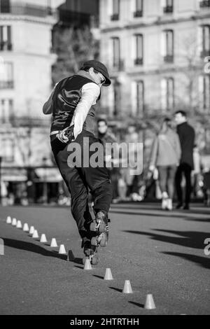 Paris, Frankreich - 27. Februar 2022 : Ein Pariser Rollschuh, der an einem sonnigen Tag in Schwarz-Weiß für die Touristen in Paris auftrat Stockfoto