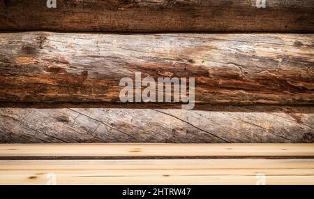 Leerer Holzdecktisch in Perspektive. Rauer Holz Baum Stamm Wand Hintergrund. Stockfoto