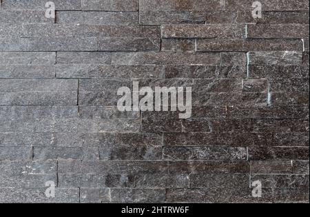 Graue Steinstreifen. Moderne dekorative Steinwand Verkleidung Textur Hintergrund. Stockfoto