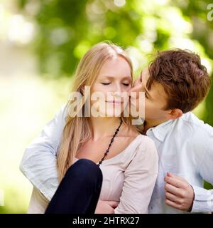 Shes seine Nummer eins. Junges Paar sitzt zusammen im Park. Stockfoto