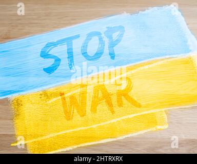 Stop war Text auf blau-gelbe ukrainische Flagge. Foto Stockfoto