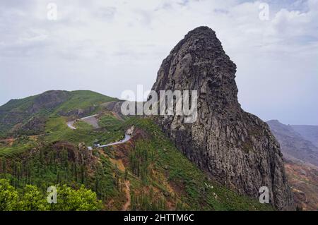 Panoramablick auf Roque de Agando von einem Aussichtspunkt in der Nähe von Vallehermoso (La Gomera, Kanarische Inseln, Spanien) mit dem Nationalpark Garajonay im Hintergrund Stockfoto