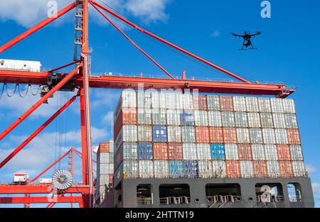 Drohne fliegt über den Containern auf dem Schiff im Hafen. Konzept: Drohnentechnologie, Rotes Meer, Angriff, Entführungsüberwachung, Sicherheit, Drohnenangriff... Stockfoto