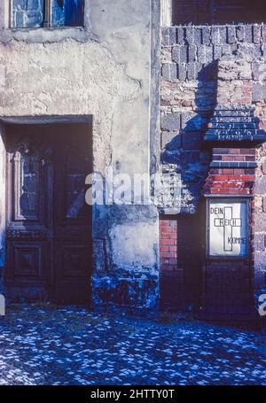 West-Berlin 1962. 'Dein Königreich komm' auf einer Säule vor der Kirche in der Bernauer Straße, die von der Mauer blockiert ist. Stockfoto