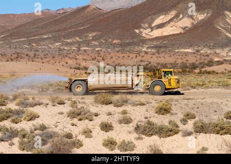 Henderson, NV, USA – 17. Februar 2022: Ein Entstaubungs-LKW mit einem Wassersprüher, der auf einer Feldstraße in Henderson, Nevada, fährt. Stockfoto