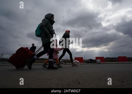 Medyka, Polen. 2. März 2022. Flüchtlinge gehen nach dem Grenzübertritt aus der Ukraine eine Straße entlang. Nach Angaben der Vereinten Nationen hat Polen seit dem Einmarsch Russlands am 24. Februar bisher mindestens 281.000 Flüchtlinge aus der Ukraine aufgenommen. Unterdessen wüten in der Ukraine Kämpfe zwischen ukrainischen Streitkräften und der eindringenden russischen Armee. (Bild: © Bryan Smith/ZUMA Press Wire) Stockfoto