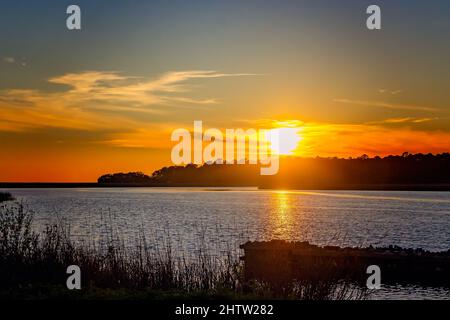 Die Sonne geht am 1. März 2022 in Delta Port Marina in CODEN, Alabama, unter. Der 14,4 Meilen lange West Fowl River entspringt in Theodore, Alabama. Stockfoto