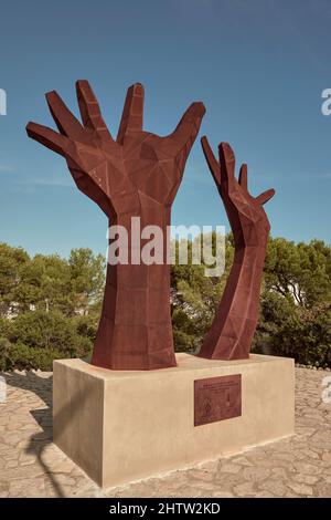 Skulptur Symbol des Widerstands und der Verteidigung demokratischer Werte im Blickpunkt des Leuchtturms. Zwei Hände blicken in den Himmel in Cullera, Valencia Stockfoto