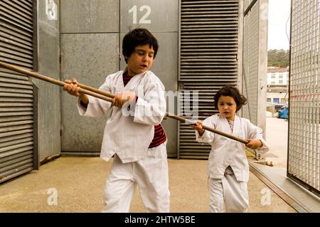 Zwei Kinder spielen Karate auf der Straße Stockfoto