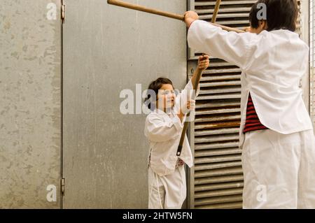 Zwei Kinder spielen Karate auf der Straße Stockfoto