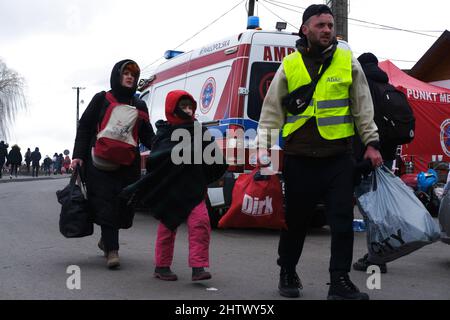 Moskau/Kiew. 2. März 2022. Ein Freiwilliger begleitet Menschen aus der Ukraine, die am 28. Februar 2022 die Grenze in Medyka, Polen, verlassen. Quelle: Meng Dingbo/Xinhua/Alamy Live News Stockfoto