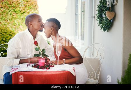 Sie verdienen es, wie Könige behandelt zu werden. Eine kurze Aufnahme eines glücklichen jungen Paares, das ein romantisches Abendessen im Freien hat. Stockfoto