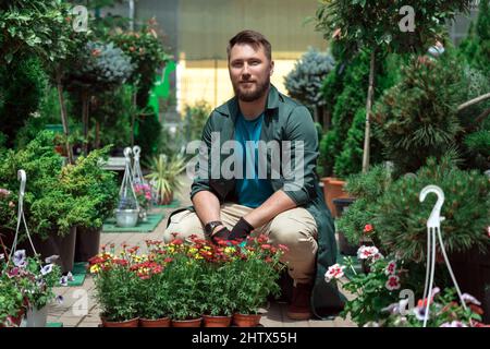 Gärtner, die im Gartencenter mit Blumen arbeiten Stockfoto