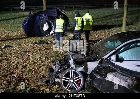 Hamburg, Deutschland. 03. März 2022. Polizeibeamte inspizieren das Wrack im grünen Bereich am Unfallort. Ein Fahrer kollidierte am A7 in Hamburg mit einem anderen Auto und starb. Quelle: Jonas Walzberg/dpa/Alamy Live News Stockfoto