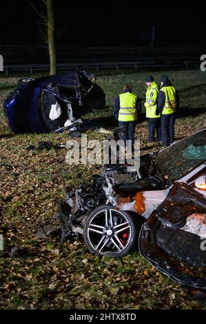 Hamburg, Deutschland. 03. März 2022. Polizeibeamte inspizieren das Wrack im grünen Bereich am Unfallort. Ein Fahrer kollidierte am A7 in Hamburg mit einem anderen Auto und starb. Quelle: Jonas Walzberg/dpa/Alamy Live News Stockfoto