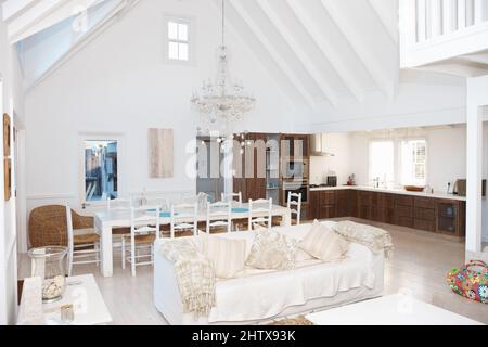 Luxuriöses Wohnzimmer mit Küche und Esstisch im Hintergrund. Interieur eines geräumigen modernen Wohnzimmers mit Küche im Hintergrund. Stockfoto
