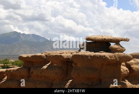 1500 Jahre alter verwitterter Adobe Brick in der Wüste von New Mexico mit Sandia Mountain Range im Hintergrund. Stockfoto