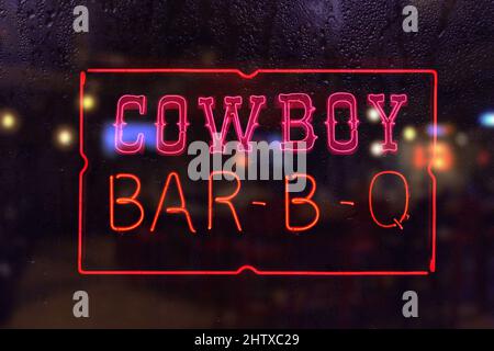 Cowboy Barbecue Neon-Schild im regnerischen Fenster Stockfoto