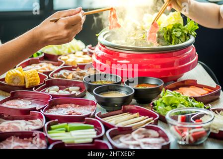 Genießen Sie den Verzehr von Shabu Shabu und Sukiyaki in einem heißen Topf im japanischen Restaurant.Japanisches Essen ist qualitativ hochwertiges Essen, das in einer heißen Suppe mit Gemüse b zubereitet wird Stockfoto