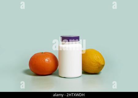 Modell. Ein weißer Kunststoffbehälter auf einem Holzständer, Zitrone und Mandarin Stockfoto