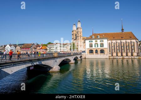 Münsterbrücke und Grossmünster mit Helmhaus und Wasserkirche im Abendlicht, Reflexion im Fluss, historische Brücke über die Limmat, Alt Stockfoto