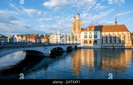 Münsterbrücke und Grossmünster mit Helmhaus und Wasserkirche im Abendlicht, Reflexion im Fluss, historische Brücke über die Limmat, Alt Stockfoto